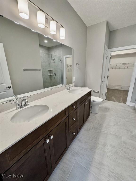 full bath with double vanity, a sink, toilet, and a shower stall