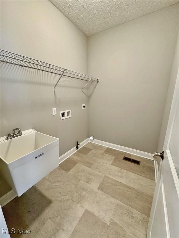 washroom featuring washer hookup, visible vents, a sink, electric dryer hookup, and laundry area