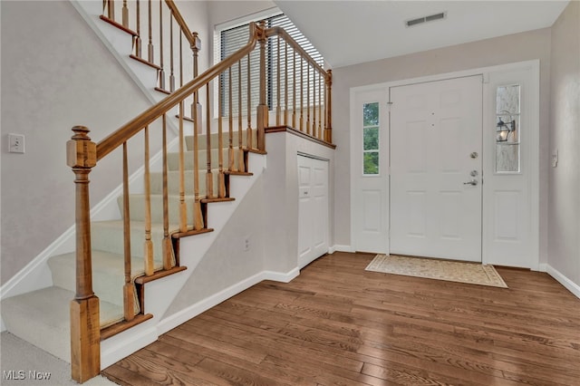 entryway with visible vents, stairs, baseboards, and wood finished floors