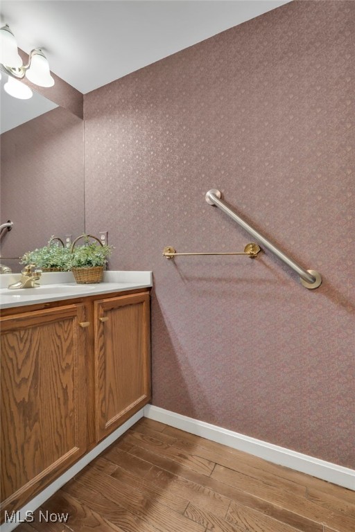 bathroom featuring vanity, wood finished floors, and baseboards