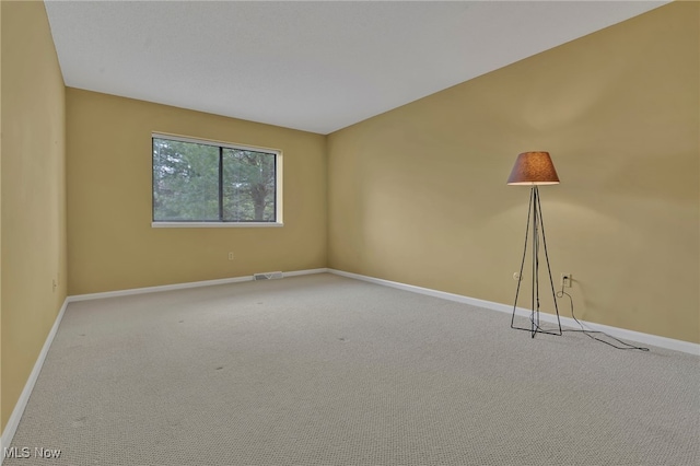 carpeted empty room with visible vents and baseboards