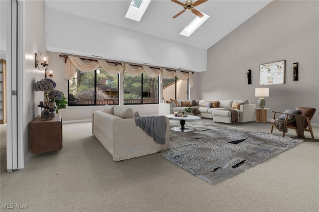 living area featuring a skylight, high vaulted ceiling, and ceiling fan