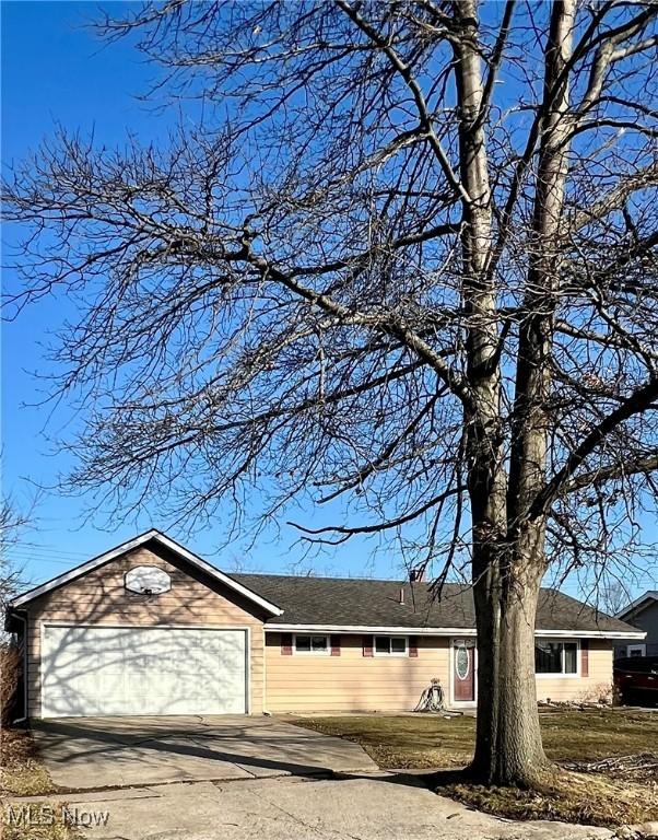 view of side of home featuring an attached garage and concrete driveway