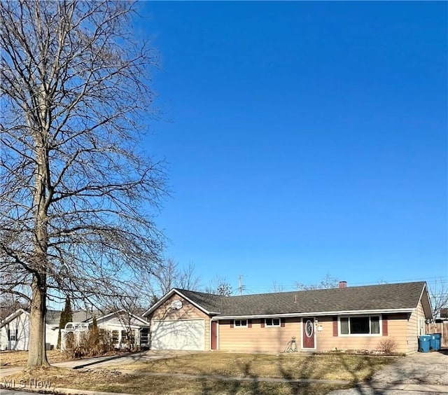 ranch-style house with a garage, driveway, and a chimney