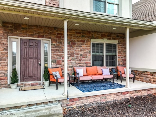 view of exterior entry featuring covered porch, outdoor lounge area, and stucco siding