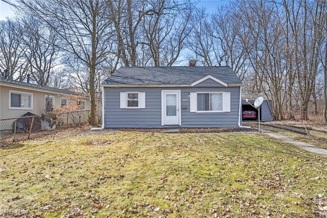 bungalow-style house with a shingled roof, a chimney, fence, and a front lawn