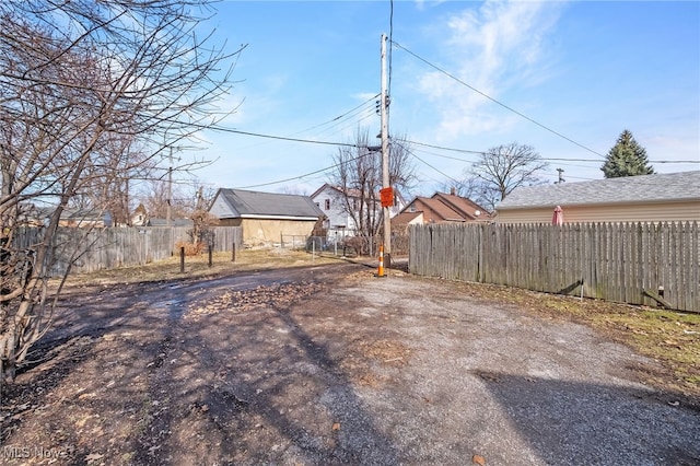 view of yard with aphalt driveway and fence