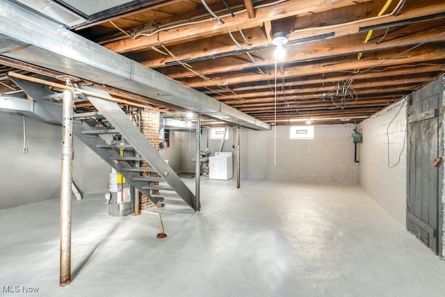 below grade area featuring washer / dryer, water heater, and stairway