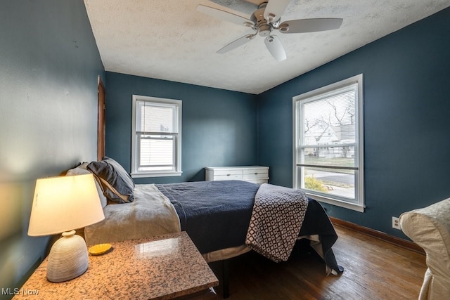 bedroom featuring a textured ceiling, ceiling fan, wood finished floors, and baseboards