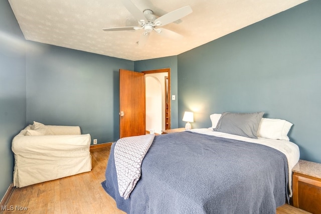 bedroom with wood finished floors, a ceiling fan, and baseboards