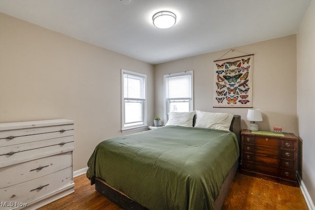 bedroom with baseboards and wood finished floors