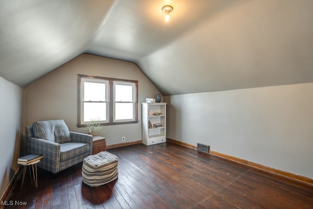 sitting room featuring dark wood-style floors, lofted ceiling, visible vents, and baseboards