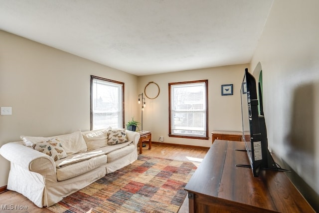 living area with light wood-style flooring and baseboards