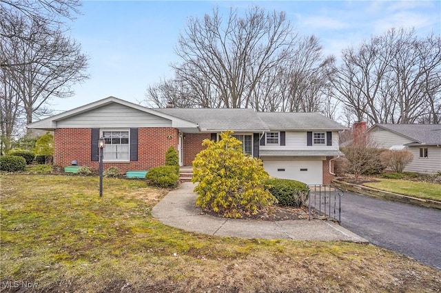 view of front of home with aphalt driveway, brick siding, a chimney, and an attached garage