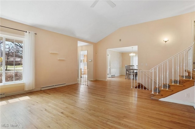 entryway featuring vaulted ceiling, baseboards, stairs, and light wood-style floors