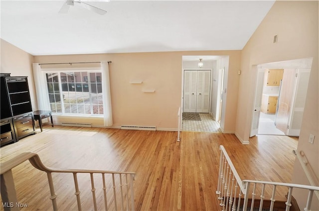 living area with light wood finished floors, baseboards, vaulted ceiling, and a ceiling fan