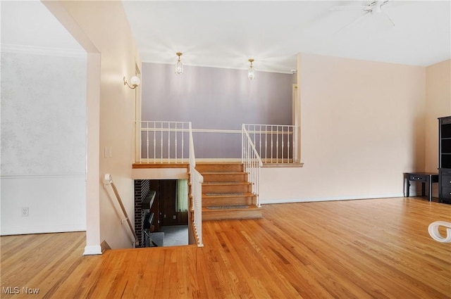 unfurnished living room featuring stairway and wood finished floors