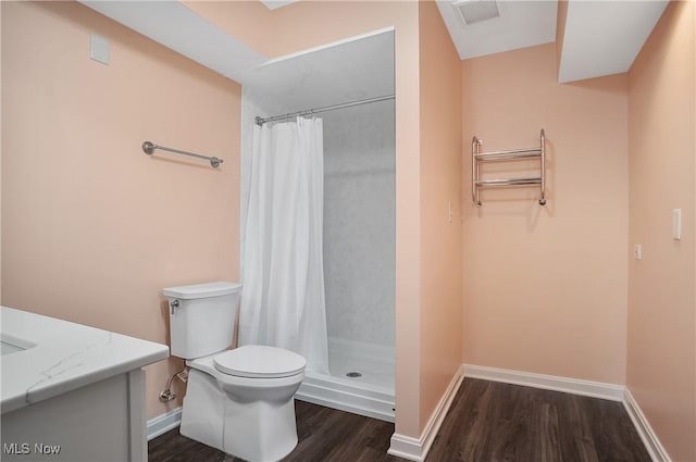 bathroom featuring toilet, wood finished floors, visible vents, baseboards, and a stall shower