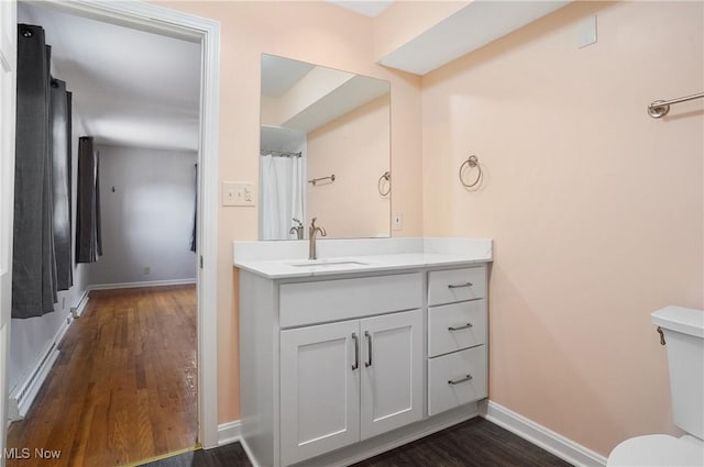 full bath with vanity, wood finished floors, toilet, and baseboards