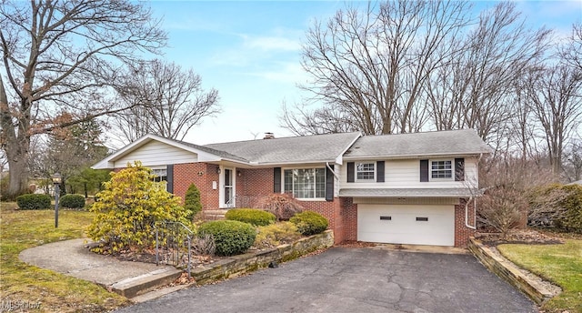 ranch-style house with brick siding, driveway, a chimney, and an attached garage