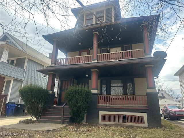 view of front of house with a balcony and brick siding