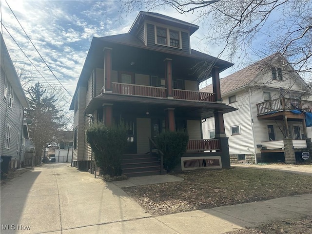 traditional style home featuring driveway, a porch, and a balcony