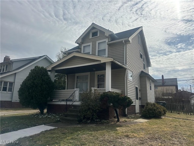 view of front of property featuring covered porch and a front lawn