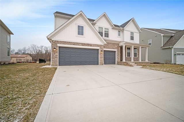 view of front of home featuring concrete driveway, board and batten siding, a front yard, a garage, and stone siding