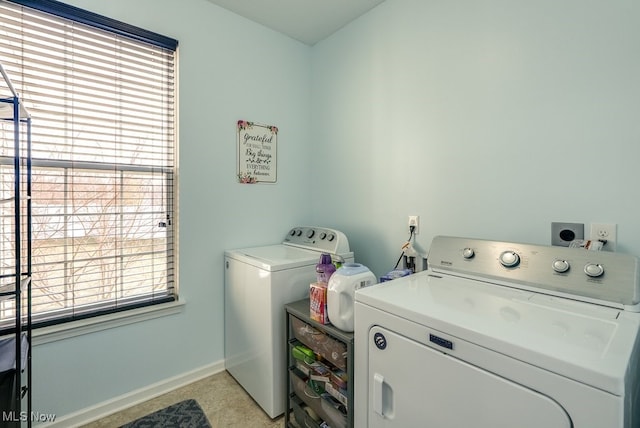 washroom featuring laundry area, washing machine and dryer, and baseboards