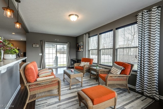 living area with baseboards and wood finished floors