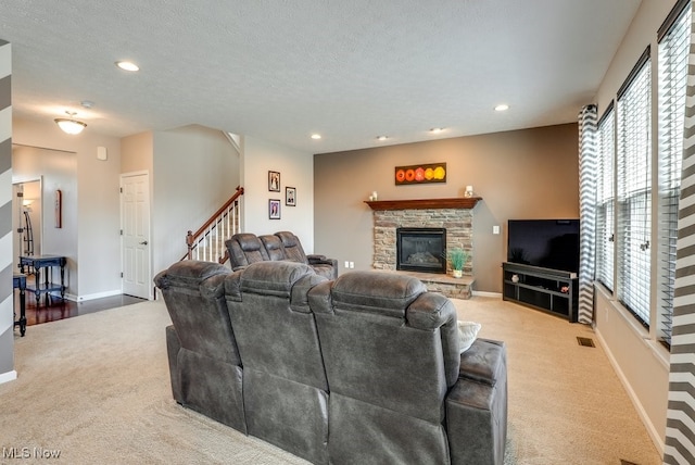 carpeted living room featuring recessed lighting, a fireplace, a textured ceiling, and baseboards