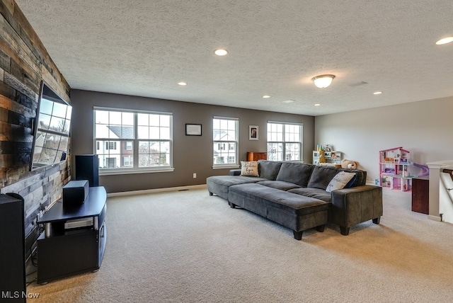 carpeted living area featuring baseboards, a textured ceiling, and recessed lighting