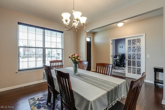 dining area featuring a chandelier, visible vents, dark wood finished floors, and baseboards