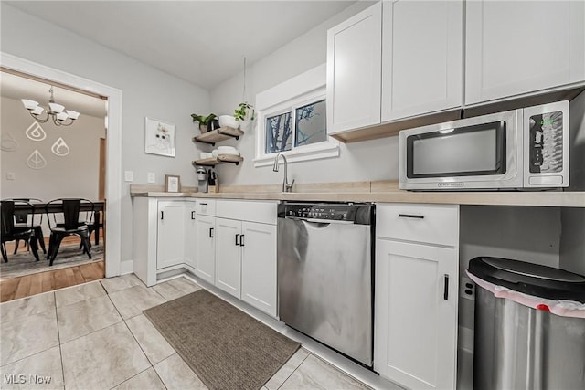 kitchen with open shelves, white cabinetry, stainless steel appliances, and light countertops