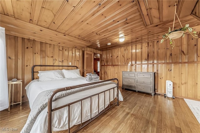 bedroom with hardwood / wood-style flooring, wood ceiling, and wooden walls