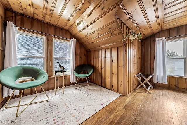 unfurnished room with vaulted ceiling, hardwood / wood-style floors, wood walls, and wooden ceiling