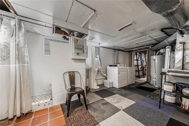 unfinished basement with concrete block wall, gas water heater, visible vents, and washer and clothes dryer