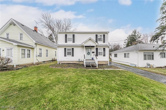 view of front of property featuring aphalt driveway and a front lawn