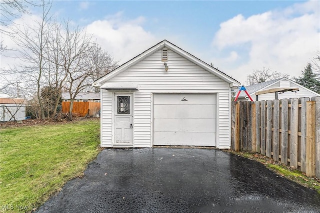 detached garage with fence and aphalt driveway