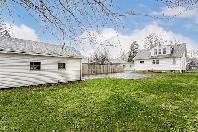 view of yard featuring a patio area, fence, and driveway