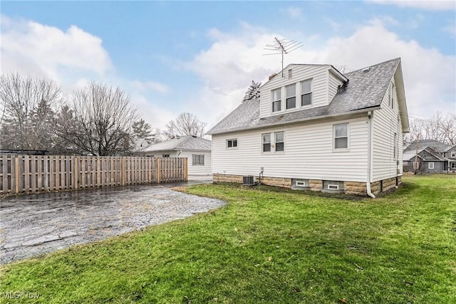 rear view of property with a shingled roof, a lawn, a patio, fence, and central air condition unit