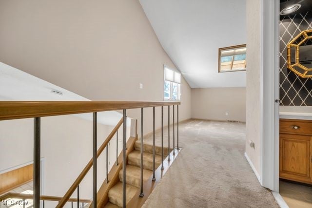 interior space with lofted ceiling and light carpet