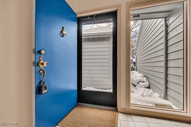 doorway to outside with tile patterned floors