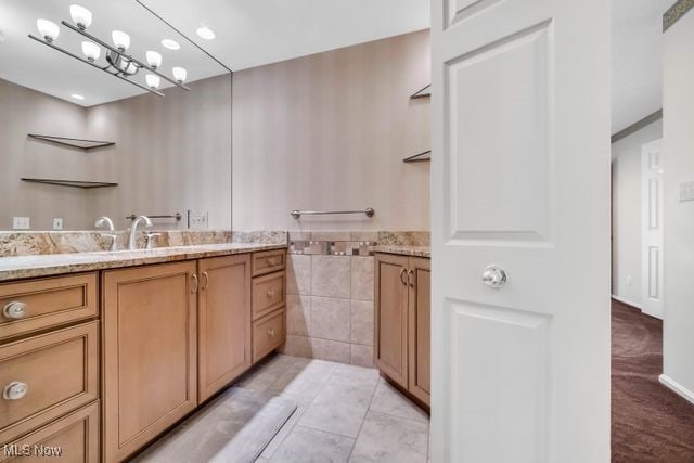 bathroom with tile patterned floors, vanity, and tile walls