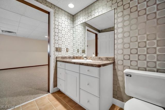 bathroom featuring tile patterned flooring, baseboards, vanity, and toilet