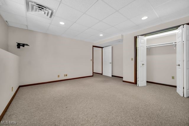 unfurnished bedroom with a drop ceiling, recessed lighting, carpet floors, visible vents, and baseboards