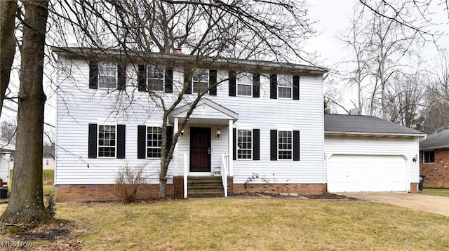 colonial-style house featuring a garage, concrete driveway, and a front lawn