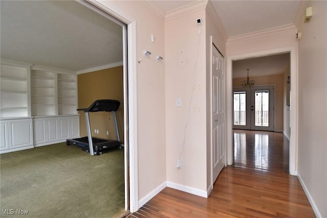 corridor with baseboards, french doors, wood finished floors, and crown molding