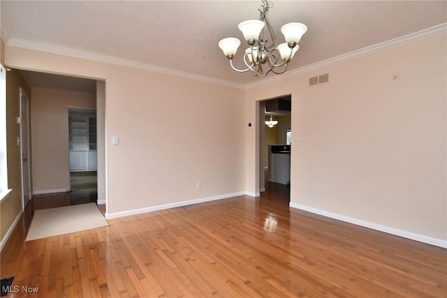 unfurnished room with a chandelier, visible vents, baseboards, light wood-style floors, and crown molding