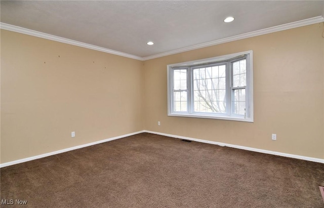 unfurnished room with dark colored carpet, recessed lighting, visible vents, ornamental molding, and baseboards